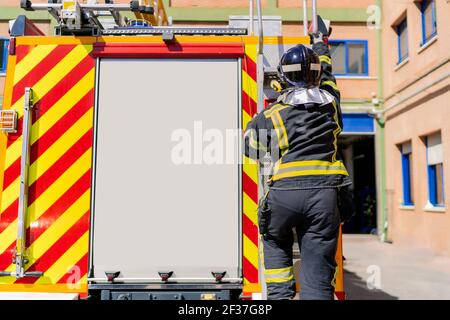 firefighter getting on the truck to work in emergency Stock Photo