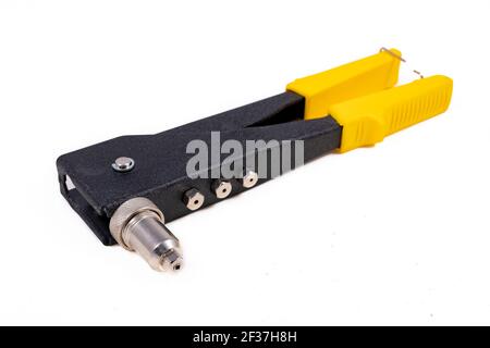 A riveter for crimping aluminum rivets. Tools for assembly in a machine shop. Light background. Stock Photo