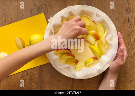 The hostess at home is preparing apple charlotte in the kitchen. puts ingredients on apple pie Stock Photo