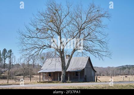 Old abandoned pioneer wood cabin with a covered front porch, in rural Alabama, USA. Stock Photo