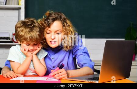 Elementary school. Education. First day at school. Little child learning with mother. Homework. Stock Photo