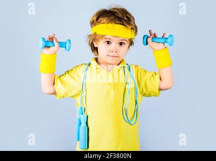 Fitness children. Sporty boy in sportswear with jump rope and dumbbells. Child sportsman. Stock Photo