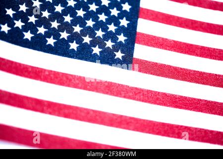 A macro shot with selective focus of a small handheld American flag on coarse fabric. Stock Photo
