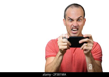 Mature man in casual clothing, with angry expression and holding smartphone horizontally. Stock Photo