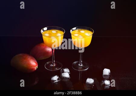 Glasses of tasty mango margarita on dark background Stock Photo