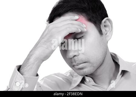 Young Asian man having headache with hand on his forehead - monochrome effect with red spot on pain area Stock Photo