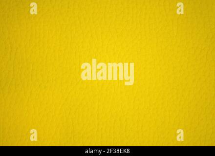 The surface of genuine leather is artificially dyed in a bright yellow color. Background, pattern, texture. Stock Photo
