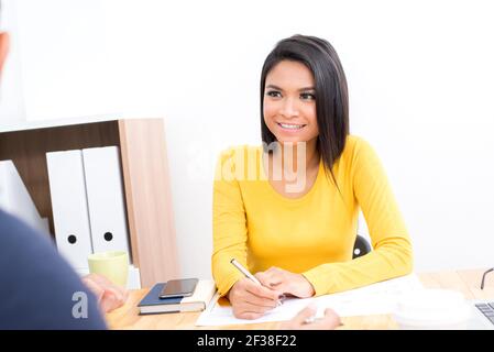 Smiling Asian woman wearing casual yellow t-shirt in the meeting - businesswoman and entrepreneur concepts Stock Photo