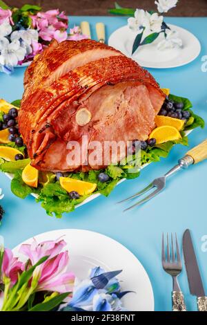 Spiral sliced glazed ham on festive table for Easter. Stock Photo
