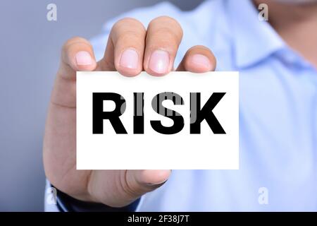 RISK word on the card shown by a man, vintage tone Stock Photo