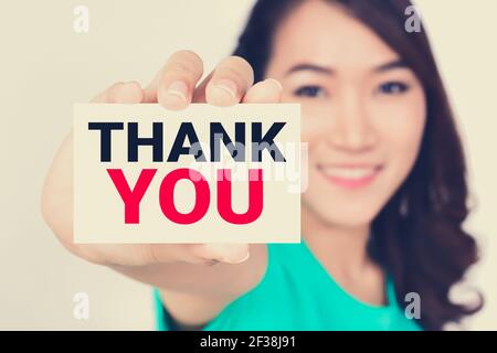 THANK YOU, message on the card shown by a woman, vintage tone Stock Photo