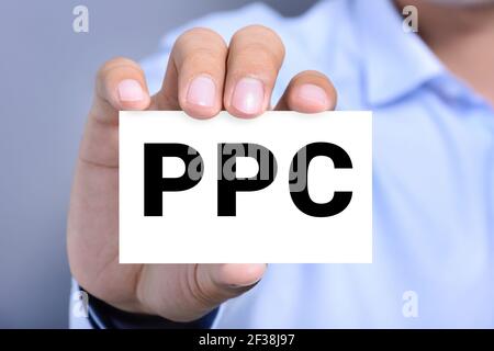 PPC (or Pay Per Click) sign on the card shown by a man Stock Photo