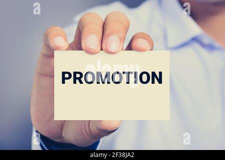 PROMOTION word on the card shown by a man Stock Photo