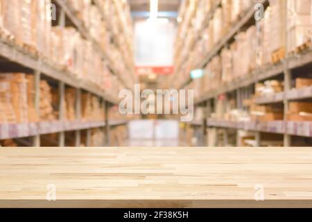 Empty wood table top on blurred warehouse background - can montage or display your products Stock Photo