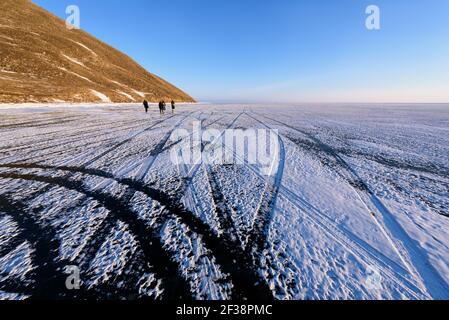 Lake Baikal in winter, the lake's surface is frozen solid that strong enough for a vehicle to pass. Tire tracks on the ice Stock Photo