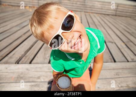 Playful preschooler with ice cream cone showing tongue Stock Photo