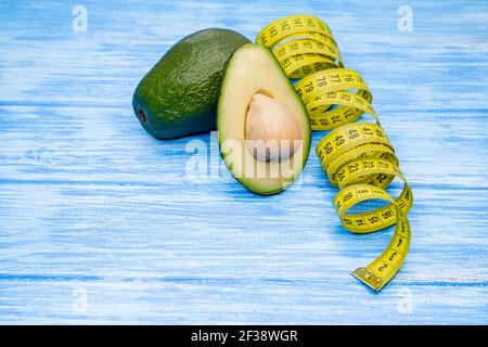 Food background with fresh organic avocado on blue table. Superfood. Stock Photo