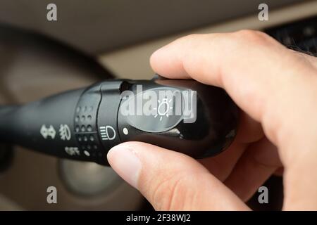 Hand adjusting car headlight control switch Stock Photo