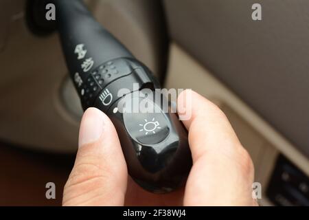Hand adjusting car headlight control switch Stock Photo