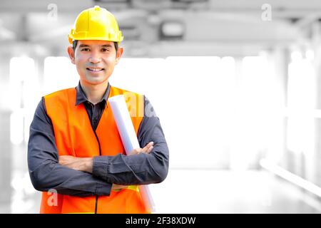 Asian architect or engineer wearing safety vest and hard hat (or helmet) Stock Photo