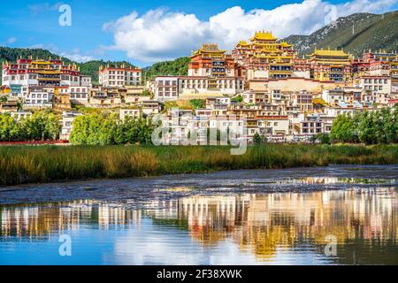 Songzanlin monastery with beautiful water reflection on lake during sunny day in Shangri-La Yunnan China Stock Photo