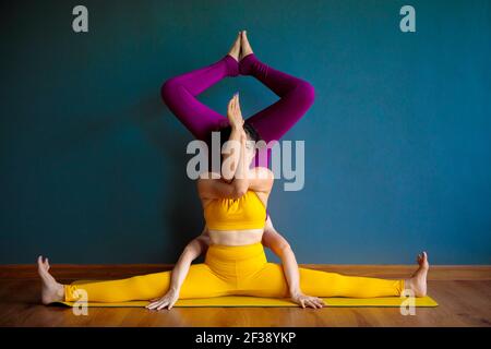 two asian woman doing yoga pose in home living room Stock Photo