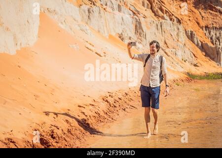 Man tourist on the Fairy stream among the red dunes, Muine, Vietnam. Vietnam opens borders after quarantine COVID 19 Stock Photo