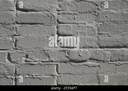 Detail of old brick exterior wall with many times painted surface in layers, gray hue, sun lighting Stock Photo
