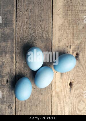 Naturally colored organic eggs on a rustic table with space for text, Easter background Stock Photo