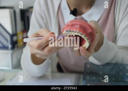 Dental staff showing how to clean between braces Stock Photo