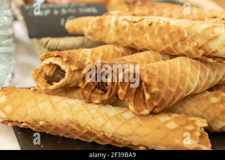 Homemade waffle rolls with condensed milk on buffet. Stock Photo