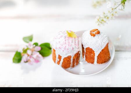 Easter holiday. Two decorated easter cakes on a plate with apple blossom. Top view. Copy space. Stock Photo