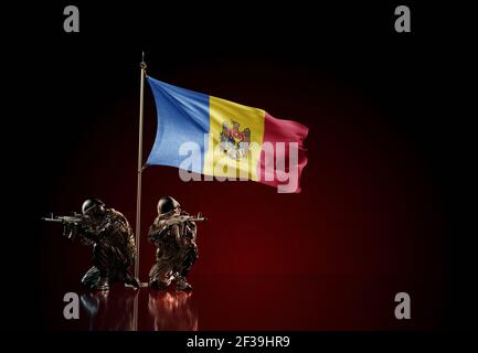 Concept of military conflict with soldier statues and waving national flag of Moldova. Illustration of coup idea. Two guards defending the symbol Stock Photo