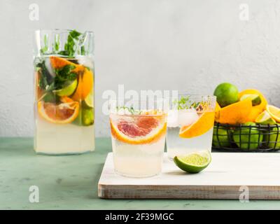 Fresh summer citrus drink with ice on green Stock Photo