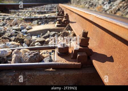 Old aged nuts and bolts on railroad concrete sleepers Stock Photo