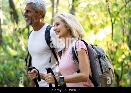 Smiling mature couple hiking together in forest Stock Photo