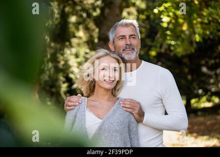 Happy mature couple standing in backyard Stock Photo