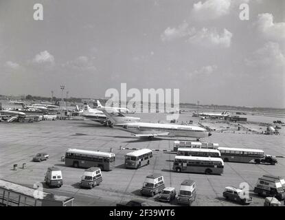 1960s, historical view of jet aircraft of the era, including a Boeing 727 Lufthansa aeroplane,with BEA passenger coaches and smaller vans on the tarmac beside the runway at London Airport, London, England, UK. In 1966, the British Airports Authority was created and London Airport is renamed as Heathrow, the name coming from the village where the airport was built. Stock Photo