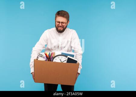 Deeply upset depressed man employee crying standing and holding in hands things in cardboard box, feeling sadness, dismissed from job, staff reduction Stock Photo