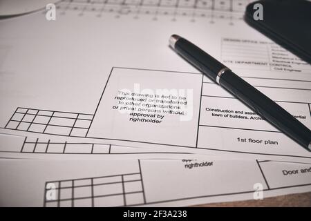 Engineering drawings and black pen at desk Stock Photo
