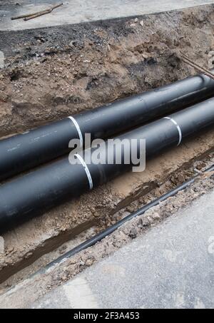 Replacing district heating pipes under a street. Stock Photo