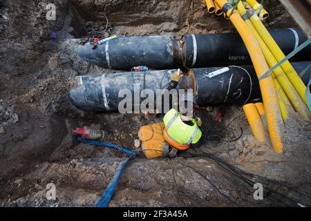 Replacing district heating pipes under a street. Stock Photo