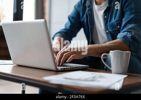 Entrepreneur working with a laptop and holding a document in a little office or home Stock Photo