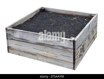 Aged  wooden box filled with  soil for growing plants. Isolated on white Stock Photo