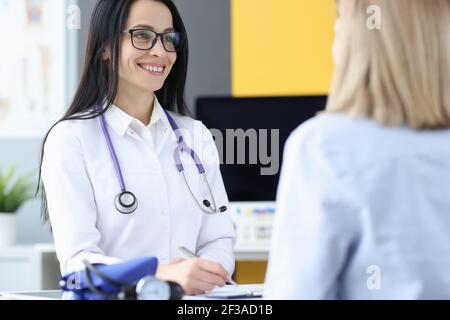 Woman doctor communicating with patient in clinic Stock Photo