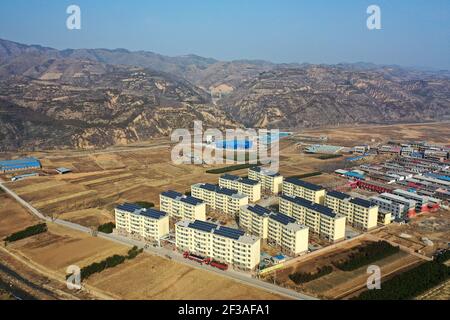 (210316) -- TAIYUAN, March 16, 2021 (Xinhua) -- Aerial photo taken on March 9, 2021 shows a residential compound for relocated villagers in Yukou Town of Fangshan County, north China's Shanxi Province. Shijiamao is a small village located in rugged mountainous areas with little rainfall. Like other villagers here, Liu Qingji, an 85-year-old farmer, used to do farming at the mercy of the elements. Having dwelled many years in a gloomy 'yaodong', a house built into the hardened earth common across the Loess Plateau in northern China, Liu hoped to improve the living conditions and have access to Stock Photo