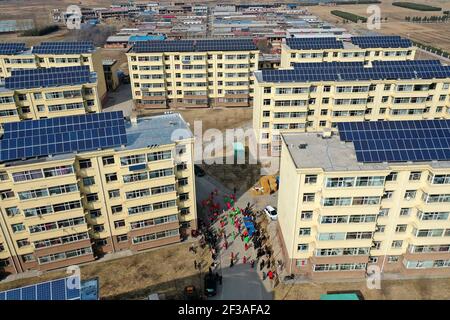 (210316) -- TAIYUAN, March 16, 2021 (Xinhua) -- Aerial photo taken on March 9, 2021 shows villagers performing yangge dance at a residential compound for relocated villagers in Yukou Town of Fangshan County, north China's Shanxi Province. Shijiamao is a small village located in rugged mountainous areas with little rainfall. Like other villagers here, Liu Qingji, an 85-year-old farmer, used to do farming at the mercy of the elements. Having dwelled many years in a gloomy 'yaodong', a house built into the hardened earth common across the Loess Plateau in northern China, Liu hoped to improve the Stock Photo