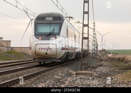 Gallur, Spain - February 20, 2021: Regional express train, originating at Delicias de Zaragoza station, passing through Gallur. Meanwhile, the sunset Stock Photo