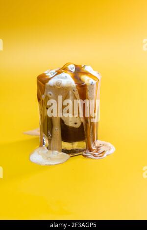 coffee drink with delicate jam and flowing foam on a yellow background Stock Photo