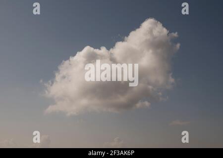 a one single white cloud in a bright blue sky day, minimalist landscape Stock Photo